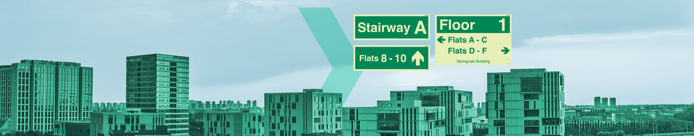 Directional signage for "Stairway A" and "Floor 1" with flat numbers, against an urban skyline.