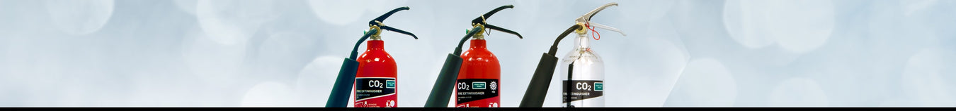 CO2 fire extinguishers in red and black with hoses, set against a bokeh effect background.